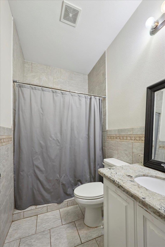 4592 Shakespeare Ln, Kountze, TX 77625 - bathroom featuring tile walls, vanity, curtained shower, and a wainscoted wall
