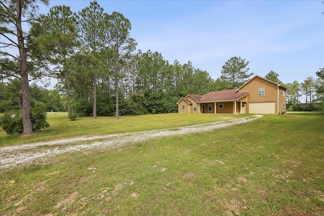 4592 Shakespeare Ln, Kountze, TX 77625 - view of green lawn with dirt driveway and an attached garage