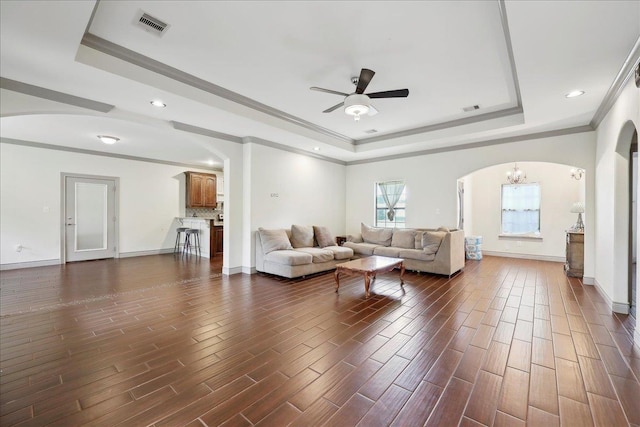 4592 Shakespeare Ln, Kountze, TX 77625 - living room with a raised ceiling, arched walkways, a ceiling fan, dark wood-style floors, and crown molding