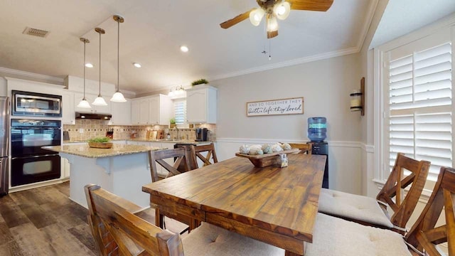 dining room with sink, ceiling fan, dark hardwood / wood-style flooring, and crown molding