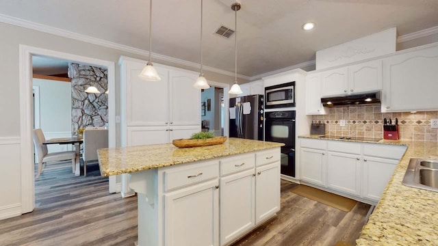 kitchen featuring white cabinets, pendant lighting, and black appliances