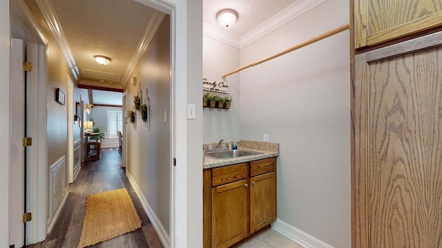 hall featuring light wood-type flooring, ornamental molding, and sink