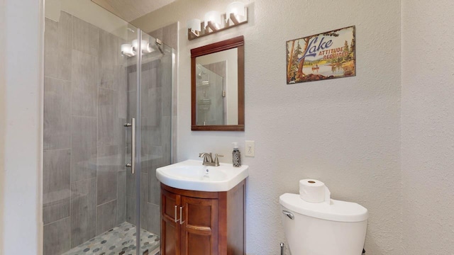 bathroom featuring an enclosed shower, vanity, and toilet