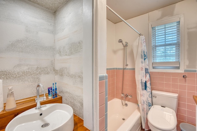 3325 Blackmon Ln, Beaumont, TX 77703 - bathroom featuring tile walls, a sink, shower / bath combo with shower curtain, toilet, and wood finished floors