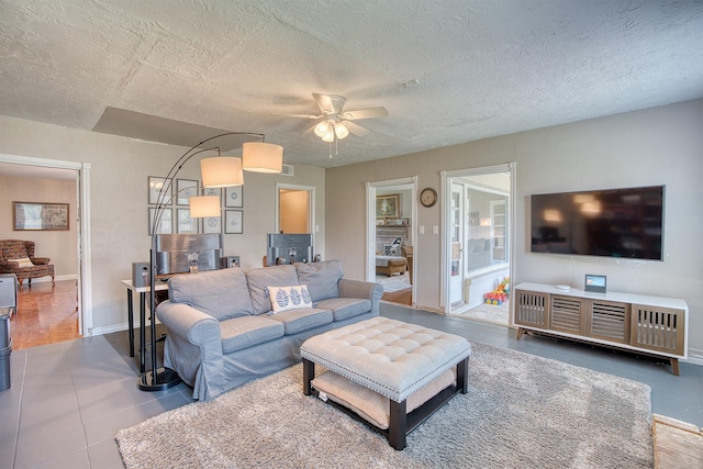 3325 Blackmon Ln, Beaumont, TX 77703 - tiled living room featuring ceiling fan, a textured ceiling, and baseboards