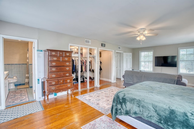 3325 Blackmon Ln, Beaumont, TX 77703 - bedroom with french doors, light wood-style flooring, a ceiling fan, ensuite bath, and a walk in closet