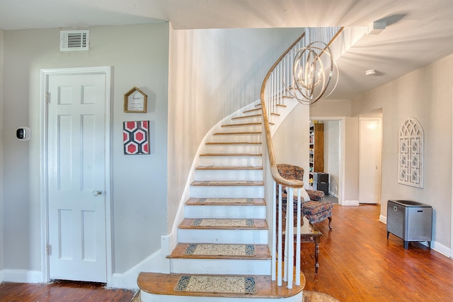 3325 Blackmon Ln, Beaumont, TX 77703 - staircase featuring wood finished floors, a chandelier, and baseboards