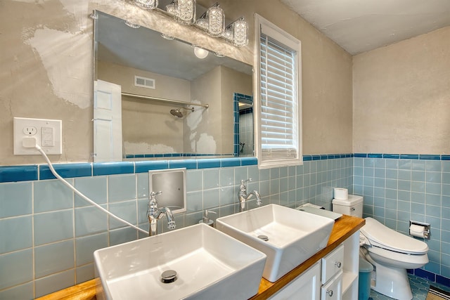 3325 Blackmon Ln, Beaumont, TX 77703 - bathroom featuring tile walls, vanity, toilet, a shower, and wainscoting