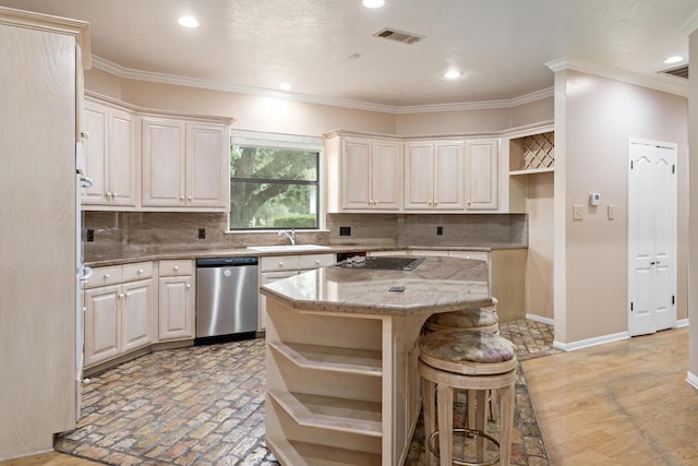 kitchen featuring light stone counters, a breakfast bar, sink, dishwasher, and a kitchen island