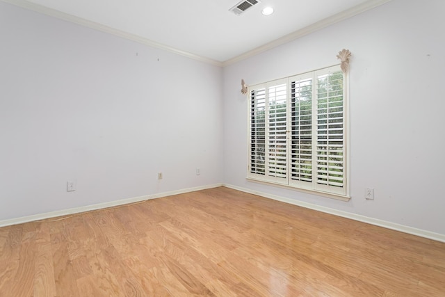 empty room featuring light hardwood / wood-style flooring and crown molding