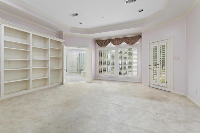 unfurnished room with a tray ceiling, french doors, carpet, and a healthy amount of sunlight