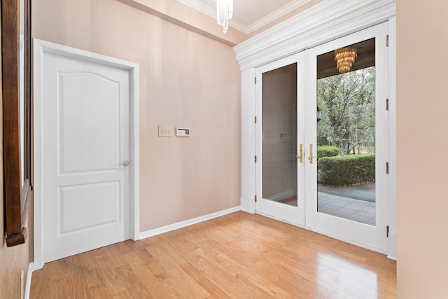 doorway with a chandelier, french doors, light hardwood / wood-style floors, and ornamental molding