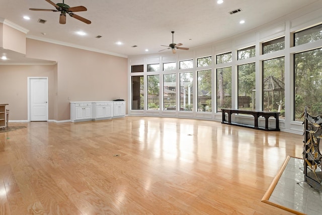 unfurnished living room featuring ceiling fan, light hardwood / wood-style floors, and ornamental molding