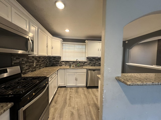 5333 Lakeside Dr, Port Arthur, TX 77642 - kitchen featuring stainless steel appliances, white cabinetry, tasteful backsplash, light wood-style floors, and recessed lighting