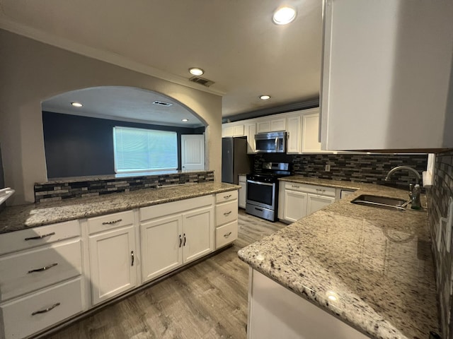 5333 Lakeside Dr, Port Arthur, TX 77642 - kitchen featuring appliances with stainless steel finishes, tasteful backsplash, white cabinetry, light stone counters, and recessed lighting