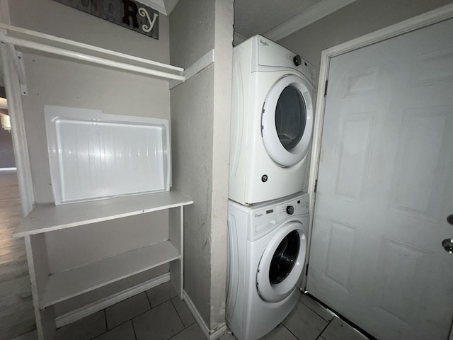 5333 Lakeside Dr, Port Arthur, TX 77642 - laundry room featuring estacked washer and dryer, tile patterned floors, and a textured wall