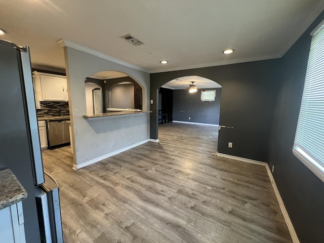 5333 Lakeside Dr, Port Arthur, TX 77642 - unfurnished living room featuring ceiling fan, ornamental molding, arched walkways, wood finished floors, and plenty of natural light