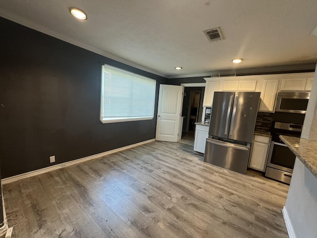 5333 Lakeside Dr, Port Arthur, TX 77642 - kitchen with appliances with stainless steel finishes, crown molding, white cabinets, light wood-style flooring, and light stone countertops