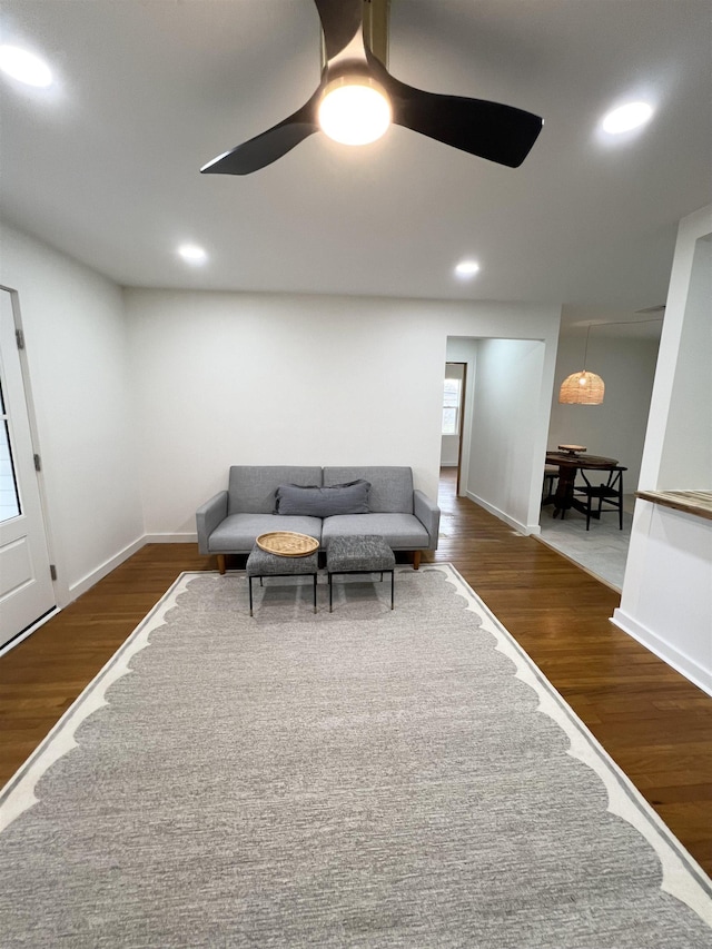 living room featuring dark hardwood / wood-style flooring and ceiling fan