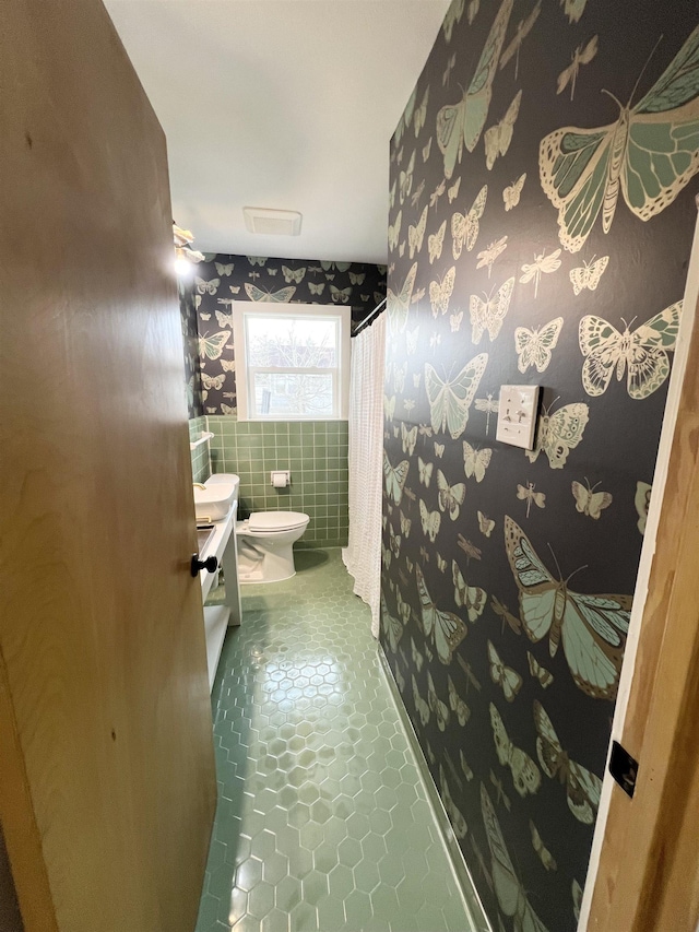 bathroom with vanity, toilet, tile patterned flooring, and tile walls