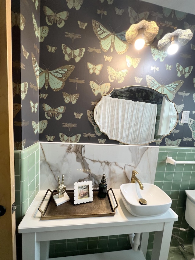 bathroom featuring tile walls, sink, and toilet