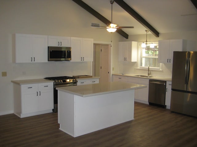 kitchen featuring white cabinetry, sink, hanging light fixtures, a kitchen island, and appliances with stainless steel finishes