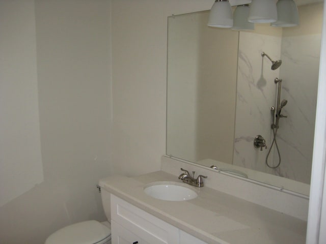 bathroom featuring a shower, vanity, and toilet