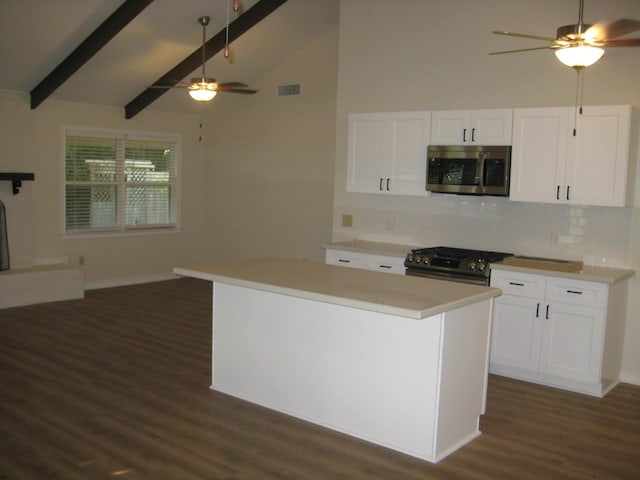 kitchen featuring decorative backsplash, stainless steel appliances, beam ceiling, white cabinets, and a center island