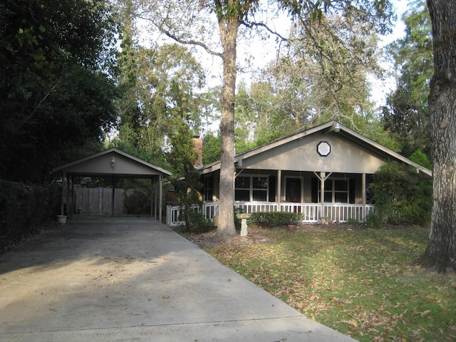 ranch-style home featuring a front yard, a porch, and a carport