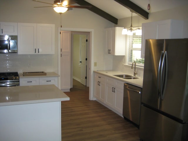 kitchen with lofted ceiling with beams, sink, hanging light fixtures, white cabinetry, and stainless steel appliances