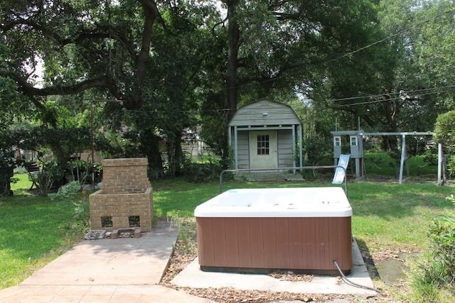 4246 Griffing Dr, Port Arthur, TX 77642 - view of green lawn featuring a hot tub, an outdoor brick fireplace, and an outbuilding