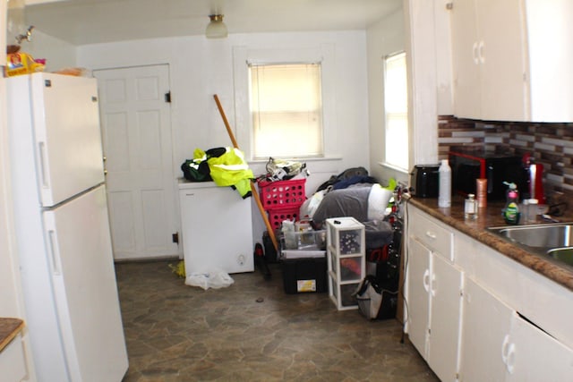 3575 Magnolia Ave, Beaumont, TX 77703 - kitchen with freestanding refrigerator, stone flooring, and white cabinetry