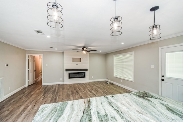 unfurnished living room with ceiling fan, a fireplace, crown molding, and hardwood / wood-style flooring