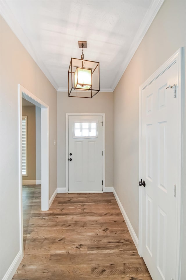 foyer entrance featuring an inviting chandelier, ornamental molding, and hardwood / wood-style floors