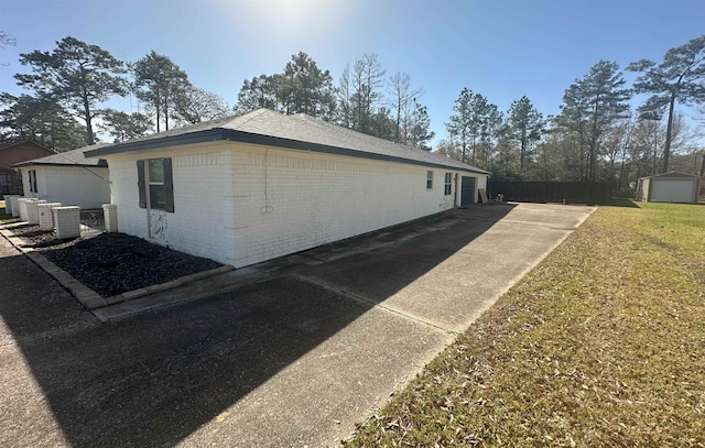 view of side of property with central AC and a yard