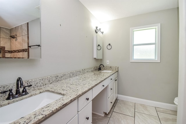 bathroom with toilet, vanity, and tile patterned floors