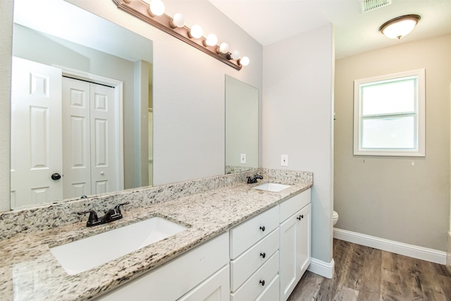 bathroom with toilet, vanity, and hardwood / wood-style floors