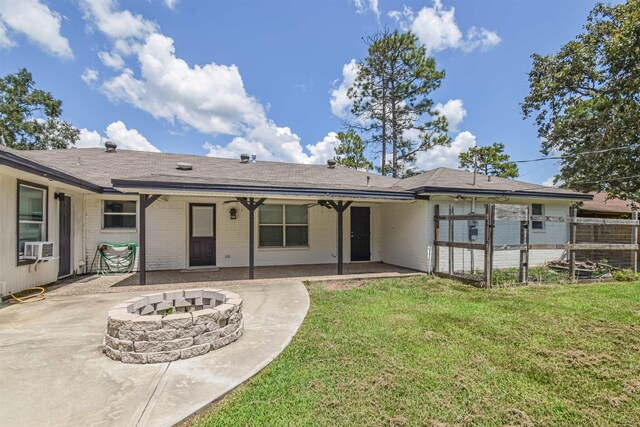 back of house featuring a yard, a fire pit, and a patio