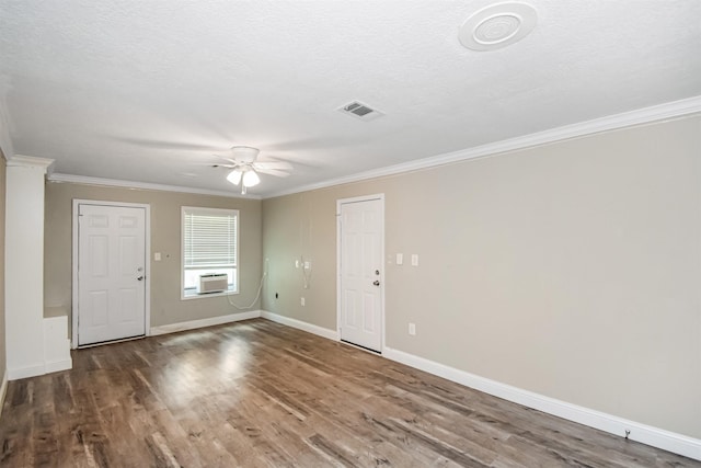 interior space with a textured ceiling, cooling unit, dark hardwood / wood-style flooring, ornamental molding, and ceiling fan