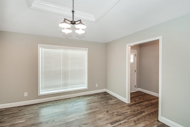 empty room with dark hardwood / wood-style floors, crown molding, a notable chandelier, and a healthy amount of sunlight