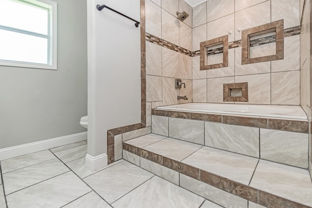 bathroom featuring tiled shower / bath combo and toilet