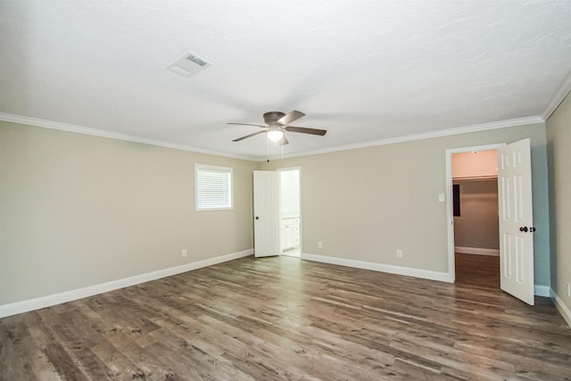 interior space featuring ceiling fan, a spacious closet, ornamental molding, and dark hardwood / wood-style floors