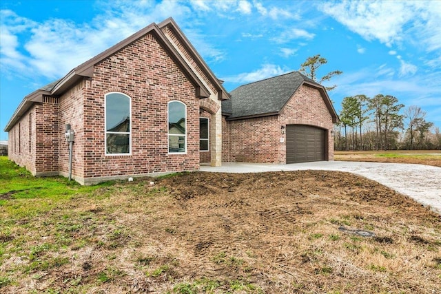 view of front of house featuring an attached garage, brick siding, driveway, and roof with shingles