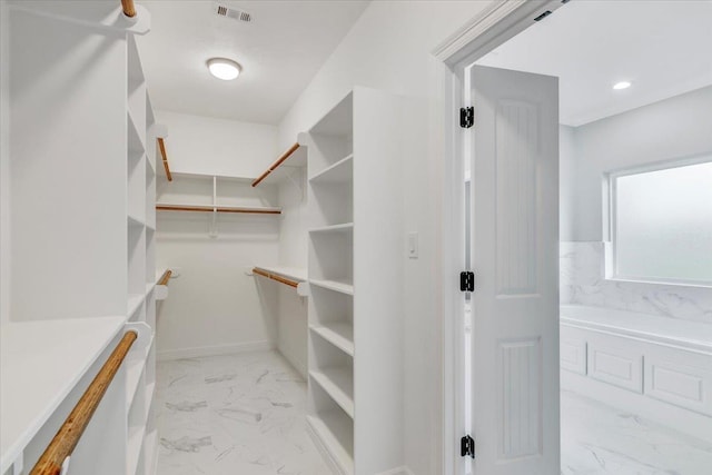 spacious closet featuring visible vents and marble finish floor