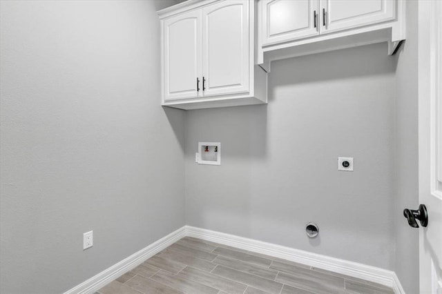 washroom with hookup for a washing machine, baseboards, wood tiled floor, cabinet space, and electric dryer hookup