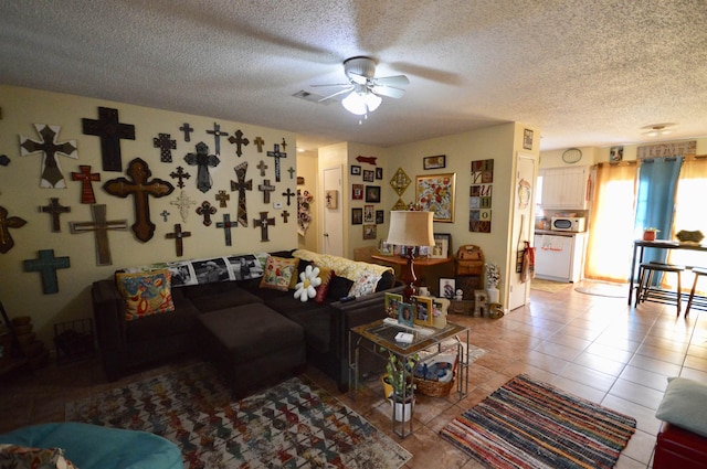 tiled living room with a textured ceiling and ceiling fan