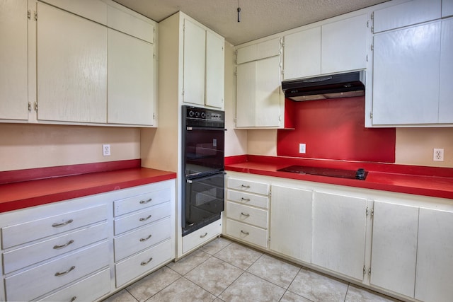 kitchen with black appliances, light tile patterned flooring, white cabinetry, and a textured ceiling