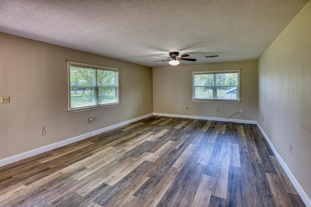 spare room featuring a textured ceiling, dark hardwood / wood-style flooring, a wealth of natural light, and ceiling fan