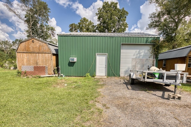 view of outbuilding with a lawn and a wall unit AC