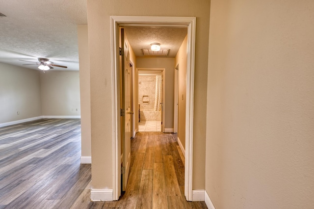 hall featuring hardwood / wood-style flooring and a textured ceiling